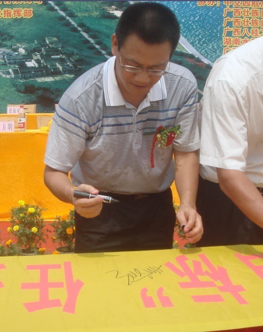 廣西新港灣公司副總經(jīng)理姚方明在“奮戰100天，如期實(shí)現魚(yú)梁工程截流、通航、發(fā)電‘三大目標’”橫幅上簽字